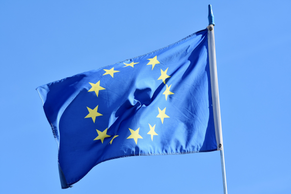 powiewająca flaga UE na niebieskim tle